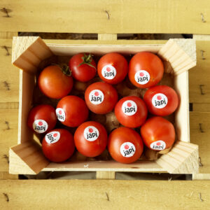 Frische Bio-Tomaten der Marke Japi in einer Holzkiste, nachhaltig verpackt und bereit für den Versand